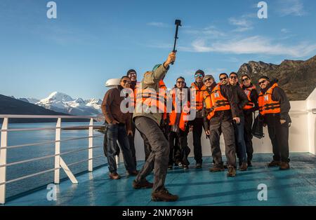 Touristen, selfie, Ventus Kreuzfahrtschiff, im Hintergrund der Cordillera Darwin, Ainsworth Bay, PN Alberto De Agostini, Feuerland, Patagonien, Chile Stockfoto