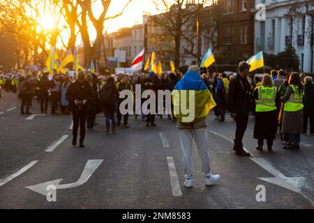 London, Großbritannien. 24. Februar 2023 Menschen in einer Prozession nach der Teilnahme an einem Ökumenischen Gedenkgebet an der Statue von Saint Volodymyr dem Großen in Holland Park auf dem Weg zu einer Nachtwache bei Kerzenschein und einer Kundgebung in der russischen Botschaft. Der Gottesdienst ist anlässlich des einjährigen Jahrestages des Beginns der russischen Invasion der Ukraine für diejenigen gedacht, die während des Konflikts in den letzten 12 Monaten ihr Leben verloren haben. Kredit: Stephen Chung / Alamy Live News Stockfoto