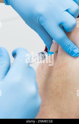 Seniorin erhält Impfstoff.Mediziner impft einen älteren Patienten gegen Grippe, Grippe, Lungenentzündung oder Coronavirus.Arzt gibt Injektion für Stockfoto