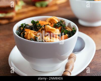 Vegane Tortellini-Suppe mit TVP und Grünkohl Stockfoto