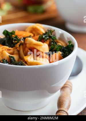 Vegane Tortellini-Suppe mit TVP und Grünkohl Stockfoto