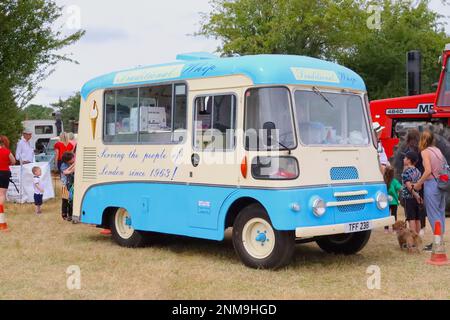 Eine klassische Dampf- und Oldtimer-Rallye mit einem Morris LD Eiswagen aus dem Jahr 1962, bei dem eine Reihe eifriger Kunden darauf warten, die Waren zu probieren. Stockfoto