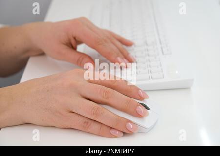 Nahaufnahme einer Handfrau mit Maus und Tastatur. Hochwertiges Foto Stockfoto