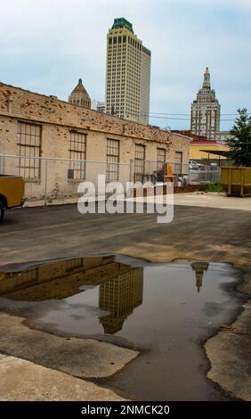 Die Skyline von Tulsa Oklahoma USA spiegelt sich in einer Pfütze auf einem Parkplatz wider Stockfoto