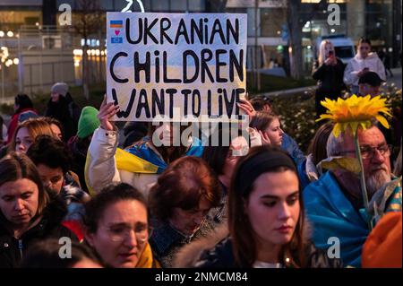 Madrid, Spanien. 24. Februar 2023. Eine Frau, die ein Plakat trägt und eine ukrainische Flagge trägt, wird während eines Protests gesehen, bei dem sich Mitglieder der ukrainischen Gemeinschaft versammelt haben, um gegen die russische Invasion der Ukraine zu protestieren, die Frieden und das Ende des Krieges fordert, zeitgleich mit dem ersten Jahrestag der russischen Invasion der Ukraine. Kredit: Marcos del Mazo/Alamy Live News Stockfoto