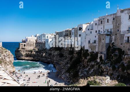 Bucht und Strand unterhalb des Dorfes an der Klippe, Mittelmeer, Menschen als Zubehör, Polignano a Mare, Apulien, Italien Stockfoto