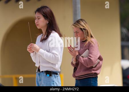 Zwei Frauen beten und bedanken sich mit Weihrauch im vietnamesischen buddhistischen Tempel Quang Minh, Melbourne, Australien. Stockfoto