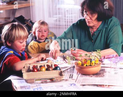 Enkelkinder, hier am 22.03.1997. In Iserlohn, vor Ostern, mit Oma, DEU, Deutschland, Eier malen Stockfoto