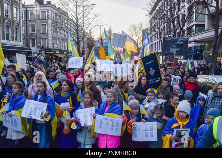 London, Großbritannien. 24. Februar 2023. Demonstranten halten Schilder mit den Namen von Kindern, die während der russischen Anschläge im vergangenen Jahr, während der Demonstration in Notting Hill Gate, starben. Tausende von Menschen marschierten aus Holland Park in die russische Botschaft während eines Protestes gegen die Ukraine am ersten Jahrestag der russischen Invasion. Kredit: SOPA Images Limited/Alamy Live News Stockfoto