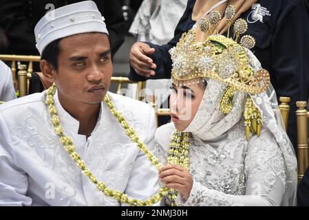 Bandung, Indonesien. 24. Februar 2023. Ein behindertes Paar führt am 24. Februar 2023 während der behinderten Massenhochzeit in Bandung, West-Java, Indonesien, eine Hochzeitsprozession durch. Die Massenhochzeit, an der sieben behinderte Paare teilnahmen, fand im Rahmen einer Reihe von Veranstaltungen statt. Auf dem Indonesia Wedding Festival 2,0 und als Anliegen für diejenigen, die Schwierigkeiten oder Einschränkungen bei der Heirat haben. (Foto: Dimas Rachmatsyah/INA Photo Agency/Sipa USA) Guthaben: SIPA USA/Alamy Live News Stockfoto