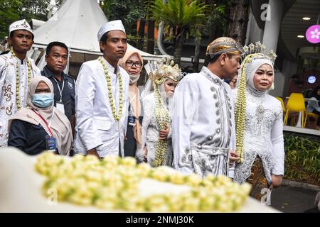 Bandung, Indonesien. 24. Februar 2023. Ein behindertes Paar führt am 24. Februar 2023 während der behinderten Massenhochzeit in Bandung, West-Java, Indonesien, eine Hochzeitsprozession durch. Die Massenhochzeit, an der sieben behinderte Paare teilnahmen, fand im Rahmen einer Reihe von Veranstaltungen statt. Auf dem Indonesia Wedding Festival 2,0 und als Anliegen für diejenigen, die Schwierigkeiten oder Einschränkungen bei der Heirat haben. (Foto: Dimas Rachmatsyah/INA Photo Agency/Sipa USA) Guthaben: SIPA USA/Alamy Live News Stockfoto