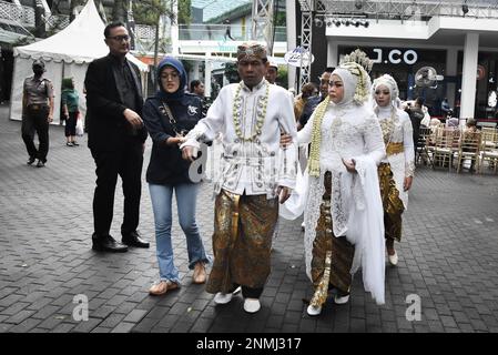 Bandung, Indonesien. 24. Februar 2023. Ein behindertes Paar führt am 24. Februar 2023 während der behinderten Massenhochzeit in Bandung, West-Java, Indonesien, eine Hochzeitsprozession durch. Die Massenhochzeit, an der sieben behinderte Paare teilnahmen, fand im Rahmen einer Reihe von Veranstaltungen statt. Auf dem Indonesia Wedding Festival 2,0 und als Anliegen für diejenigen, die Schwierigkeiten oder Einschränkungen bei der Heirat haben. (Foto: Dimas Rachmatsyah/INA Photo Agency/Sipa USA) Guthaben: SIPA USA/Alamy Live News Stockfoto