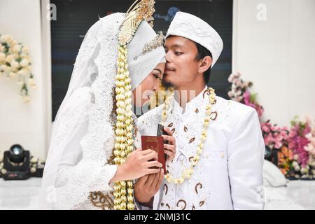 Bandung, Indonesien. 24. Februar 2023. Ein behindertes Paar führt am 24. Februar 2023 während der behinderten Massenhochzeit in Bandung, West-Java, Indonesien, eine Hochzeitsprozession durch. Die Massenhochzeit, an der sieben behinderte Paare teilnahmen, fand im Rahmen einer Reihe von Veranstaltungen statt. Auf dem Indonesia Wedding Festival 2,0 und als Anliegen für diejenigen, die Schwierigkeiten oder Einschränkungen bei der Heirat haben. (Foto: Dimas Rachmatsyah/INA Photo Agency/Sipa USA) Guthaben: SIPA USA/Alamy Live News Stockfoto