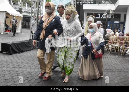 Bandung, Indonesien. 24. Februar 2023. Ein behindertes Paar führt am 24. Februar 2023 während der behinderten Massenhochzeit in Bandung, West-Java, Indonesien, eine Hochzeitsprozession durch. Die Massenhochzeit, an der sieben behinderte Paare teilnahmen, fand im Rahmen einer Reihe von Veranstaltungen statt. Auf dem Indonesia Wedding Festival 2,0 und als Anliegen für diejenigen, die Schwierigkeiten oder Einschränkungen bei der Heirat haben. (Foto: Dimas Rachmatsyah/INA Photo Agency/Sipa USA) Guthaben: SIPA USA/Alamy Live News Stockfoto