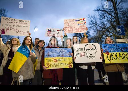 Während des Anti-Kriegs-Protests in Warschau singen Demonstranten und halten Schilder, die ihre Meinung zum Ausdruck bringen. Tausende Polen, Ukrainer und Belarussen haben sich am Jahrestag des Angriffs vor der russischen Botschaft in Warschau versammelt, um gegen Russlands Aggression gegen die Ukraine zu protestieren und Solidarität mit der Ukraine zu zeigen. Demonstranten hielten ihre nationale Flagge und auch Schilder mit den geschriebenen Namen der im Krieg gefallenen Ukrainer. Die Menge marschierte später ins parlament, um Druck auf die weitere Unterstützung der Ukraine und die Verurteilung des Krieges auszuüben. Stockfoto