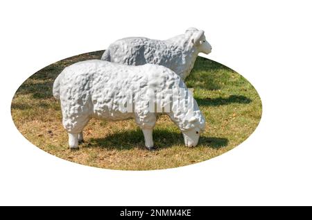 Isolierte niedliche, realistische Skulptur von zwei Schafen und Gras zur Gartendekoration auf weißem Hintergrund. Stockfoto