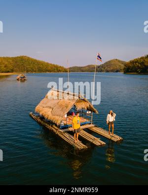 Ein paar europäische Männer und asiatische Frauen besuchen den Huai Krathing Lake im Nordosten Thailands, berühmt für seine schwimmenden Bambusfloßboote, wo Sie mittags oder abends in der Mitte des Sees zu Mittag essen können. Stockfoto