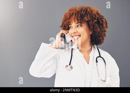 Beratung, Denken und Arzt auf einem Telefonanruf für das Gesundheitswesen isoliert auf grauem Studiohintergrund. Kontaktperson, glückliche und schwarze Frau, die auf A spricht Stockfoto