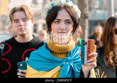 Istanbul, Türkei. 24. Februar 2023. Eine junge Frau mit der ukrainischen Flagge hält während einer Anti-Kriegs-Demonstration in Istanbul ihr Telefon auf die Aufzeichnung. Demonstranten versammeln sich in Zentral-Istanbul, der Türkei, um den einjährigen Jahrestag der russischen Invasion der Ukraine zu begehen. Nach einem Jahr russischer Invasion geht der Kampf weiter. Kredit: SOPA Images Limited/Alamy Live News Stockfoto