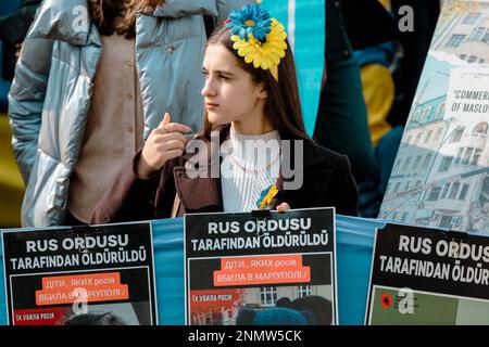 Istanbul, Türkei. 24. Februar 2023. Eine junge Demonstrantin hält während einer Anti-Kriegs-Demonstration in Istanbul Plakate, auf denen sie ihre Meinung zum Ausdruck bringt. Demonstranten versammeln sich in Zentral-Istanbul, der Türkei, um den einjährigen Jahrestag der russischen Invasion der Ukraine zu begehen. Nach einem Jahr russischer Invasion geht der Kampf weiter. Kredit: SOPA Images Limited/Alamy Live News Stockfoto