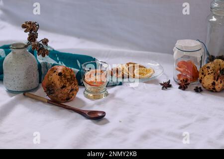 Getrocknete Zitronenscheiben und Aromaten auf einer Platte zur Vorbereitung auf eine entspannende Aromatherapie zu Hause Stockfoto