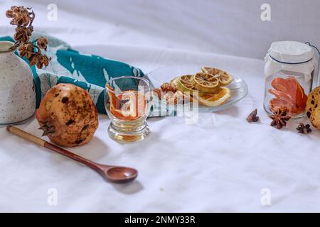 Getrocknete Zitronenscheiben und Aromaten auf einer Platte zur Vorbereitung auf eine entspannende Aromatherapie zu Hause Stockfoto