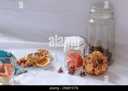 Getrocknete Zitronenscheiben und Aromaten auf einer Platte zur Vorbereitung auf eine entspannende Aromatherapie zu Hause Stockfoto