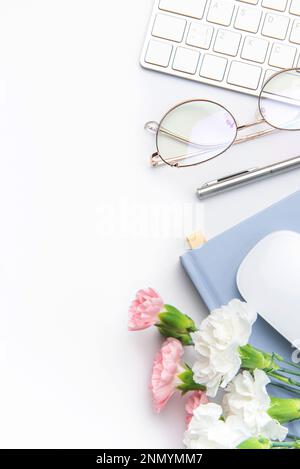 Tastatur, Computermaus und Notebook mit Stift auf weißem Büroschreibtisch. Direkt über dem Büroschreibtisch und Schreibwaren auf weißem Hintergrund Stockfoto