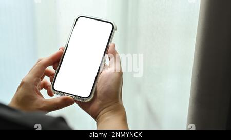 Modell eines Mannes, der sein Smartphone in der Hand hält. Leerer Bildschirm für Ihre Webseite oder Ihren Werbetext Stockfoto