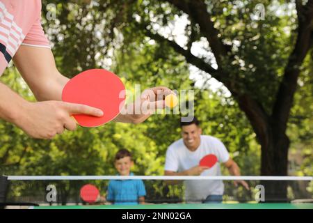 Familie mit Kind spielt Tischtennis im Park, Nahaufnahme Stockfoto