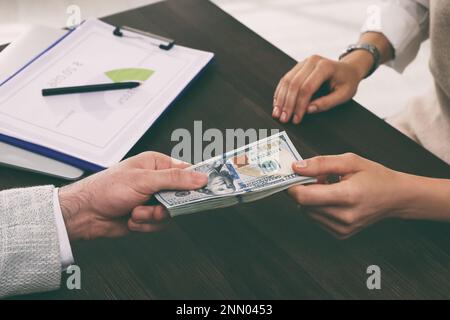 Der Kassierer gab dem Geschäftsmann Geld an der Rezeption in der Bank Stockfoto