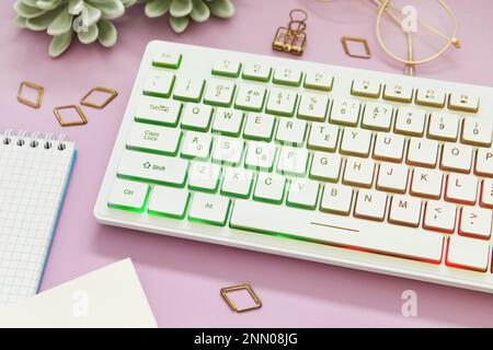 Moderne RGB-Tastatur auf pinkfarbenem Hintergrund, über der Ansicht Stockfoto