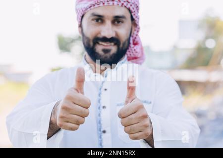 Arub muslimischer Erwachsener männlich glücklich lächelnd Daumen nach oben und sieht aus wie eine Nahaufnahme Stockfoto