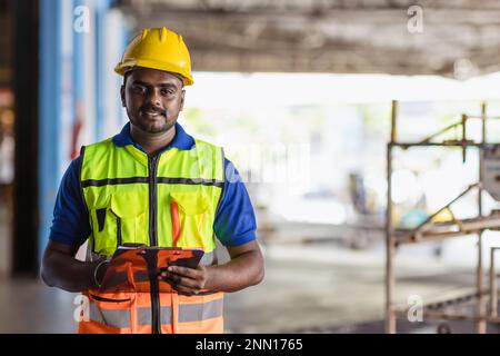 Portrait Indischer männlicher Mitarbeiter Ingenieur Vorgesetzter für Sicherheitsanzüge Arbeit im Fabriklager Stockfoto