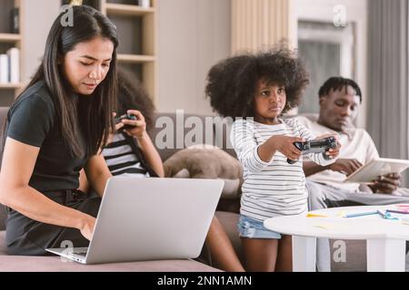 geschäftlich arbeitende mutter Frau beschäftigt Mutter Urlaub kabellos arbeiten zu Hause mit Tochter und Familie an einem Laptop Stockfoto