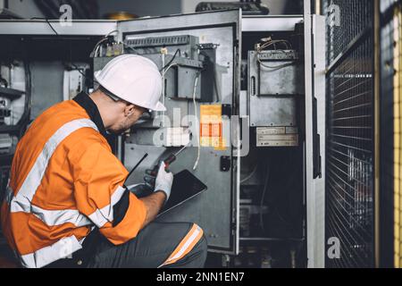 Elektroingenieur für gefährliche Arbeiten, Reparatur von Hochspannungsschaltschränken. Arbeiter reparieren Überspannungsprobleme in der Industrie Stockfoto