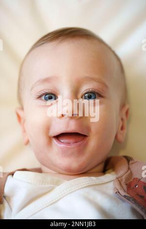 Porträt eines fröhlichen, lächelnden, blauäugigen Babys Stockfoto