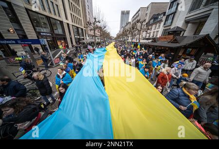 24. Februar 2023, Hessen, Frankfurt/Main: Demonstranten laufen durch die Frankfurter Innenstadt mit Stoffbannern in ukrainischen Farben. Mehrere tausend Menschen erinnerten sich an den Beginn der russischen Invasion der Ukraine. Die russische Armee war am 24.02.2022. Foto: Frank Rumpenhorst/dpa in die Ukraine eingedrungen Stockfoto