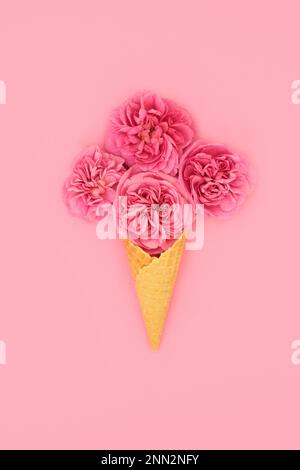 Kreative, surreale Waffeleisen mit roten Rosenblumen auf pinkfarbenem Hintergrund. Bizarres Valentinstag-, Muttertag-, Jubiläums- oder Geburtstagsgeschenk. Stockfoto