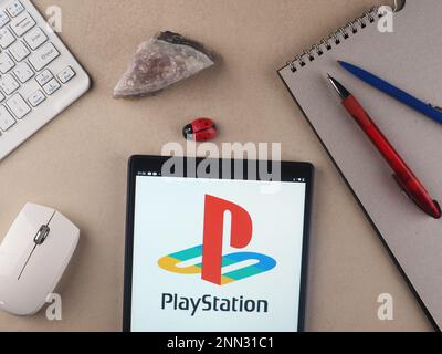 Gärtnern Sie dieses Foto mit dem PlayStation-Logo, das auf einem Tablet zu sehen ist. Stockfoto