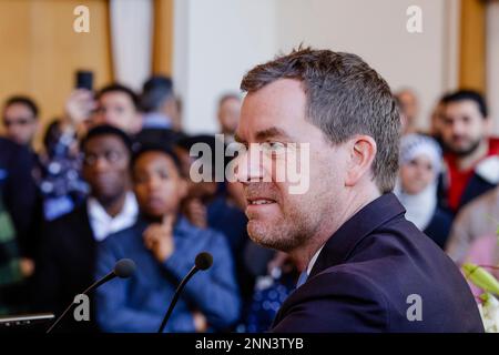 Kiel, Deutschland. 25. Februar 2023. Ulf Kämpfer (M), Oberbürgermeister der Stadt Kiel, spricht während einer Einbürgerungszeremonie in der Ratskammer des Rathauses. In der Hauptstadt des Bundesstaates wurden 2022 781 Menschen eingebürgert. Kredit: Frank Molter/dpa/Alamy Live News Stockfoto