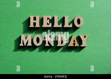 Hallo Montag, Wörter in hölzernen Buchstaben isoliert auf grünem Hintergrund Stockfoto