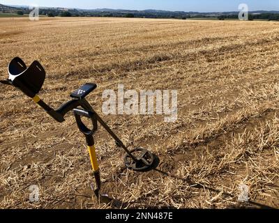 Metalldetektor und Spaten in Landschaften geernteter Stoppelfelder, Somerset, Großbritannien Stockfoto