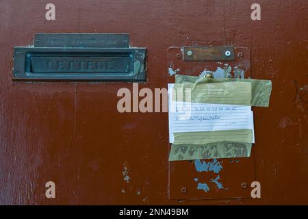 Alte Tür mit einem Stück Papier, das mit Klebeband befestigt ist, auf dem steht: "Läuten Sie nicht die Glocke", in einem ungrammatischen Italienisch, Venedig, Venetien, Italien Stockfoto