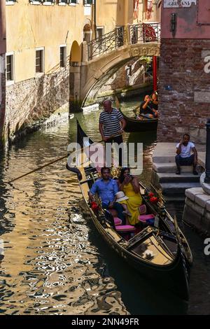 Gondeln mit Touristen auf dem Kanal Rio dei Fuseri mit der Ponte de le Colonne im Hintergrund, dem Markusviertel, Venedig, Venetien, Italien Stockfoto