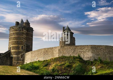 Blick auf die Mauern und Türme der mittelalterlichen Burg der französischen Stadt Fougeres, erbaut im 13. Jahrhundert, mit blauem Himmel und Wolken im Hintergrund Stockfoto