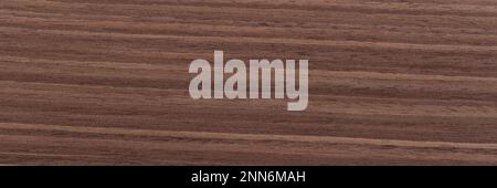 Ungewöhnlicher brauner Nussfurnier-Hintergrund für Ihren Stil. Natürliche Holzstruktur, Muster einer langen Furnierplatte, Planke. Panorama-Muster. Stockfoto