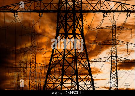 Hochspannungsmasten für Elektrizität und Kraft gegen den Himmel mit dramatischen Wolken Stockfoto
