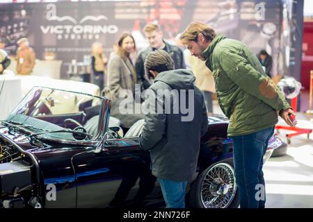 Vater und Sohn, die auf der in Madrid und Orga eröffneten ClassicMadrid-Ausstellung mit klassischen und Oldtimern den Sitzplatz eines Jaguar E Type bestaunen Stockfoto