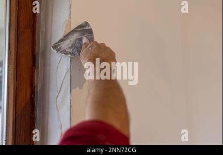 Nahaufnahme von männlichen Händepflasterungen im Hausrenovierungsprozess Stockfoto